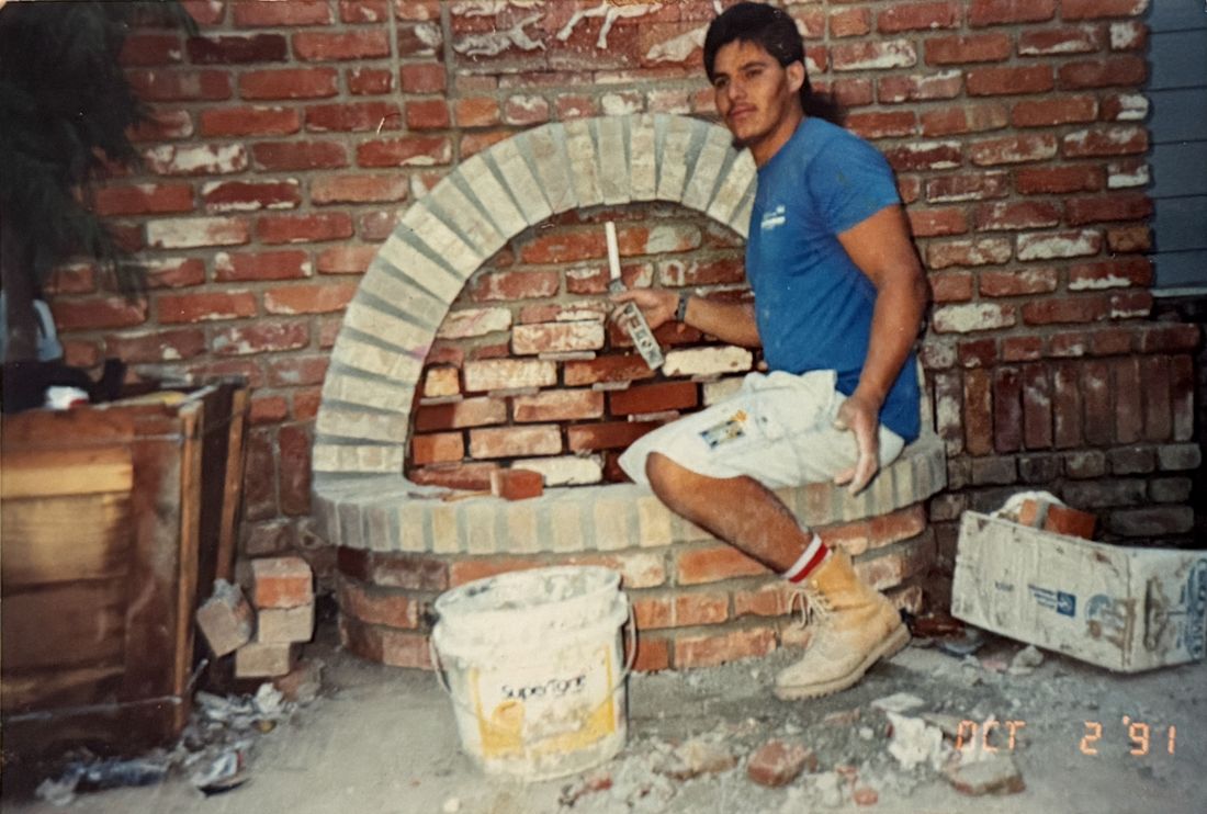 Adolfo building a brick arch fireplace, 1991
